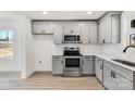 Modern kitchen with gray cabinets, stainless steel appliances, and white countertops at 219 E Rice St, Landis, NC 28088