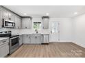 Open kitchen featuring stainless steel appliances, gray cabinetry, and a view to the back door at 219 E Rice St, Landis, NC 28088