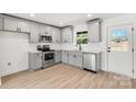 Bright kitchen featuring gray cabinetry, stainless steel appliances, and a subway tile backsplash at 219 E Rice St, Landis, NC 28088