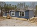 Side view of a blue single-story home featuring nice horizontal siding and large windows at 2647 Dusty Trail Ln, Lancaster, SC 29720