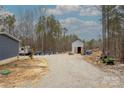 Gravel driveway leading to a metal storage building, with equipment and camper at 2647 Dusty Trail Ln, Lancaster, SC 29720