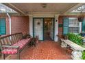 Inviting front porch with seating, red tile flooring and classic brick columns at 3021 Whitson Rd, Gastonia, NC 28054