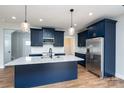 Bright kitchen featuring navy cabinets, stainless steel appliances, and granite countertops at 320 Cabarrus W Ave, Concord, NC 28025