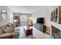 Cozy living room featuring a comfortable sofa, decorative fireplace, and a large window for natural light at 3224 Heathstead Pl, Charlotte, NC 28210