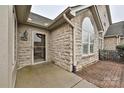 Exterior view of a stone home showcasing the front entrance and an arched window at 4709 Polo Gate Blvd, Charlotte, NC 28216