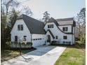 Charming home featuring a basketball hoop, a well-manicured lawn and black trimmed windows at 5608 Closeburn Rd, Charlotte, NC 28210