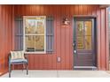 Welcoming front porch with cozy chair, a window with shutters, and a stylish front door at 607 W Stanly St, Stanfield, NC 28163