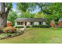 Charming single-story home featuring a well-manicured lawn, inviting walkway, and beautifully landscaped flowerbeds at 6126 Netherwood Dr, Charlotte, NC 28210