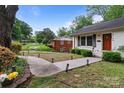 The exterior of this cozy home boasts a paved walkway and lush greenery at 6126 Netherwood Dr, Charlotte, NC 28210