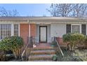 Charming front porch with brick steps, black railings, and decorative plants at 710 Peranna Pl, Charlotte, NC 28211