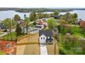 An aerial view of a newly built home and its large lot fenced for privacy near a peaceful, wooded lake at 9615 Riviera Dr, Sherrills Ford, NC 28673