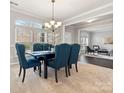 Elegant dining room featuring large windows, modern chandelier and seating for six guests at 9823 Shearwater Nw Ave, Concord, NC 28027