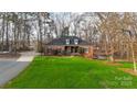 Aerial view of brick home with green lawn surrounded by mature trees at 1135 Ben Black Rd, Midland, NC 28107