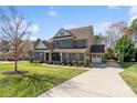 Two-story brick home with a three-car garage, a spacious yard and a long driveway at 130 Monteray Oaks Cir, Fort Mill, SC 29715