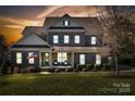 Inviting two-story brick home with a cozy front porch at dusk at 130 Monteray Oaks Cir, Fort Mill, SC 29715