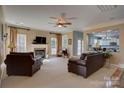 Bright living room featuring a fireplace, neutral tones, with a large window and views into the kitchen at 15100 Durmast Ct, Mint Hill, NC 28227