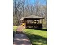 Community playground featuring a covered pavilion and a slide set against a wooded backdrop for outdoor fun at 15100 Durmast Ct, Mint Hill, NC 28227