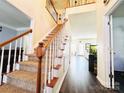 Inviting entryway with hardwood floors and a staircase with wooden banisters at 1743 Park Grove Nw Pl, Concord, NC 28027