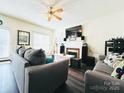 Comfortable living room with a fireplace, ceiling fan and modern furnishings at 1743 Park Grove Nw Pl, Concord, NC 28027