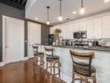 Modern kitchen featuring white cabinets, dark countertops, stylish bar stools, and modern lighting fixtures at 2338 Yadkin Ave # 503, Charlotte, NC 28205