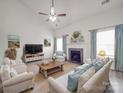 Bright living room with a fireplace, plush seating, and ample natural light from the large windows at 3114 Montcalm Ct, Monroe, NC 28110