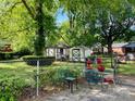 Fenced backyard featuring a table and chairs set, landscaping and several storage buildings at 3701 Seaman Dr, Charlotte, NC 28217