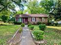 Charming brick home featuring a well-manicured lawn and beautiful, purple accents on the door and shutters at 3701 Seaman Dr, Charlotte, NC 28217
