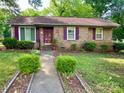 Charming brick home featuring a well-manicured lawn and beautiful, purple accents on the door and shutters at 3701 Seaman Dr, Charlotte, NC 28217