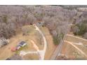 Aerial view of a wooded property with a long driveway, outbuildings, and a home at 4187 Bessie Hudson Rd, Lancaster, SC 29720