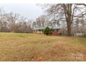 Exterior showing a brick home featuring a green metal roof, classic shutters, and mature trees at 4187 Bessie Hudson Rd, Lancaster, SC 29720