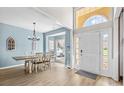 Open-concept dining area with modern chandelier, light wood flooring, and bright natural light at 717 Meadow Lake Dr, Matthews, NC 28105