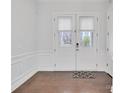 Bright foyer features hardwood floors, white wainscoting, and glass-paneled doors with a rug at 944 Treasure Ct, Fort Mill, SC 29708