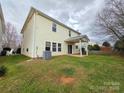 View of the home's backyard with a covered patio, lawn, and partial fence at 10927 Kinnairds St, Charlotte, NC 28278