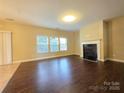 Spacious living room featuring hardwood floors, a fireplace, and large windows at 10927 Kinnairds St, Charlotte, NC 28278