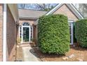 Charming front entrance with a beautiful transom window, decorative plants, and manicured hedges at 11542 Laurel View Dr, Charlotte, NC 28273