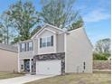 Charming two-story home featuring stone accents, gray siding, a two-car garage, and a well-maintained lawn at 124 Rustling Waters Dr, Mooresville, NC 28117