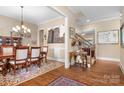 Traditional dining room with hardwood floors, elegant chandelier, and access to the staircase at 13122 Long Common Pkwy, Huntersville, NC 28078