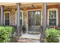 Elegant front porch with stone columns, glass entry doors, and professionally landscaped entrance at 13122 Long Common Pkwy, Huntersville, NC 28078