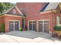 Spacious three-car garage with brick exterior and ample driveway parking at 13122 Long Common Pkwy, Huntersville, NC 28078