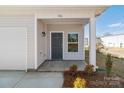 Inviting porch of a townhome with a gray door, tidy landscaping and an attached one car garage at 136 S Bell Ave, Albemarle, NC 28001