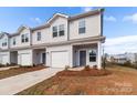 Attractive townhome showcasing a one-car garage, neutral siding, and meticulously maintained landscaping at 136 S Bell Ave, Albemarle, NC 28001
