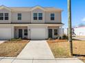 Charming townhome featuring a one car garage, neutral siding, and well manicured landscaping at 136 S Bell Ave, Albemarle, NC 28001