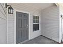 Close up of the front door, featuring a stylish gray door, sidelight, and modern sconces at 138 S Bell Ave, Albemarle, NC 28001