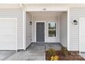 Close-up of the front entrance, featuring a stylish gray door, sidelight, and modern sconces at 138 S Bell Ave, Albemarle, NC 28001