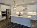 Modern kitchen features white cabinets, stainless steel appliances, a kitchen island, and stylish pendant lights at 1921 Hendricks St, Rock Hill, SC 29732