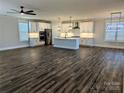 Open-concept living space with dark wood floors, a spacious kitchen with an island, and modern lighting fixtures at 1921 Hendricks St, Rock Hill, SC 29732