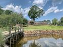 Picturesque view of the golf course and clubhouse, featuring lush greenery and a pond at 19622 River Falls Dr, Davidson, NC 28036