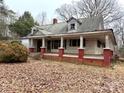 Charming home featuring a covered porch with red brick columns and mature trees in a quiet neighborhood at 2412 Daves Dr, Shelby, NC 28152