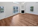 Bright living room featuring hardwood floors, fireplace, and natural light from large windows at 2802 Eagle View Ln, Monroe, NC 28110