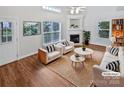 Bright living room featuring hardwood floors, fireplace, and natural light from large windows at 2802 Eagle View Ln, Monroe, NC 28110
